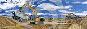 Excavator working on construction site with dramatic clouds on sky