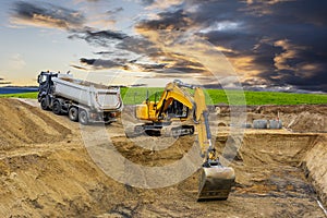 Excavator working on construction site with dramatic clouds on sky