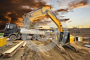Excavator working on construction site with dramatic clouds on sky