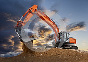 Excavator working on construction site with dramatic clouds on sky