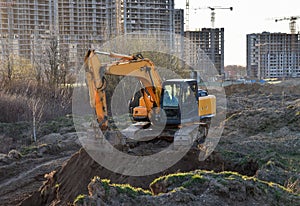 Excavator working at construction site on earthworks. Backhoe digging building foundatio. Construction machinery for excavating,