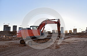 Excavator working at construction site on earthworks. Backhoe on road work digs ground. Paving out sewer line. Construction