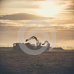 Excavator working on construction site, loading dump track