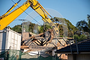 Excavator working on demolition of the resedential building.