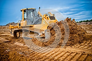 Excavator working with earth and sand in sandpit photo