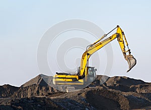 Excavator working on earthmoving at open pit mining. Backhoe digs gravel in quarry. Construction equipment and  machinery for