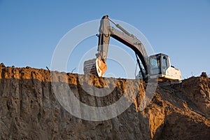 Excavator working on earthmoving at open pit mining. Backhoe digs gravel in quarry. Construction machinery for excavation, loading