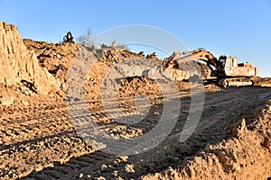 Excavator working on earthmoving at open pit mining. Backhoe digs sand and gravel in quarry. Heavy Construction Equipment Machines