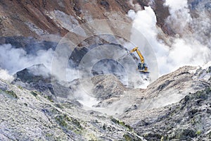 An excavator working in Jigokudani, Noboribetsu, Hokkaido. Surrounding by sulfur gas from valcano area
