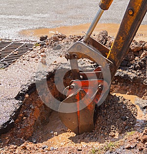 Excavator working on the Repair of pipe water on road