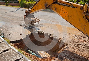 Excavator working on the Repair of pipe water on road