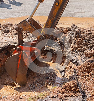 Excavator working on the Repair of pipe water and sewerage on road