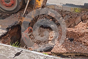 Excavator working on the Repair of pipe water and sewerage on road