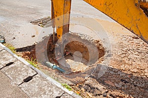 Excavator working on the Repair of pipe water and sewerage on road