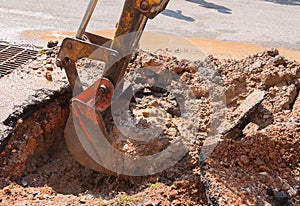 Excavator working on the Repair of pipe water and sewerage on road