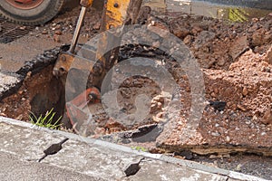 Excavator working on the Repair of pipe water and sewerage on road