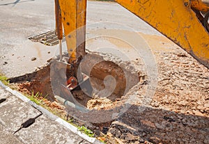 Excavator working the Repair of pipe water sewerage on road