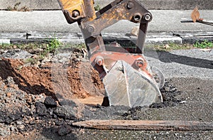 Excavator working on the Repair of pipe water and sewerage on road