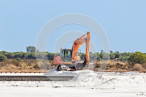 Excavator working in salt production in nature reserve Marismas del Odiel. Traditional Sea salt production is salt that is