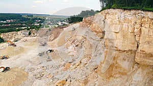 Excavator working in a sand quarry and extracting sand. An excavator picks up sand with a bucket and dumps it at the