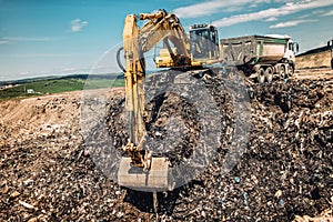 Excavator working on urban trash dumping grounds