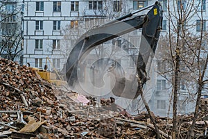 Excavator working on the wreckage of the building