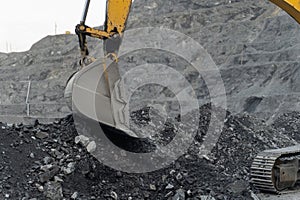 An excavator works at a gold mining site. Bucket close-up.