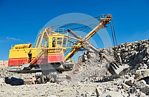 Excavator works with granite or ore at opencast mining