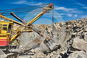 Excavator works with granite or ore at opencast mining