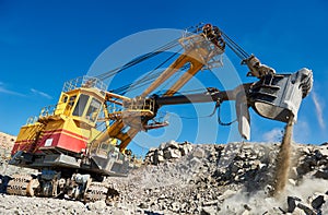 Excavator works with granite or ore at opencast mining