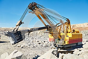 Excavator works with granite or ore at opencast mining