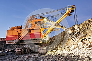 Excavator works with granite or ore at opencast mining