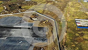 Excavator works near area with tar and foil aerial view