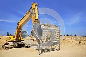 Excavator yellow vehicle on sand quarry