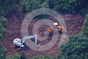 Excavators and bulldozers are being built in the green park, top view