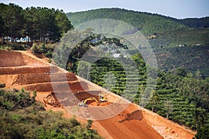 Excavators dig terraces for coffee beans plantations in Vietnam