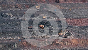 Excavators and heavy trucks in the quarry mining granite TILT-SHIFT