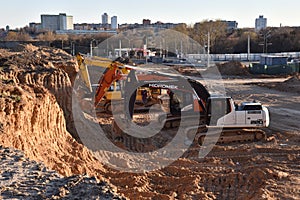 Excavators HIDROMEK, HITACHI and JCB on earthworks at construction site. Backhoe on foundation work and road construction. Tower