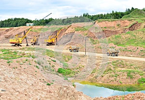 Excavators, mining trucks, wheel loader and bulldozer work in dolomite quarry. View of the industrial landscape in open pit where