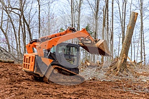 Excavators, tractors are uprooting trees for purpose of preparing site for residential a construction
