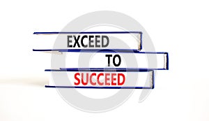 Exceed to succeed symbol. Concept words Exceed to succeed on beautiful books. Beautiful white table white background. Business and
