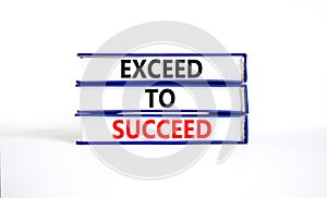 Exceed to succeed symbol. Concept words Exceed to succeed on beautiful books. Beautiful white table white background. Business and