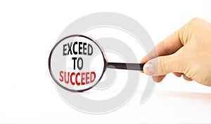 Exceed to succeed symbol. Concept words Exceed to succeed in beautiful magnifying glass. Beautiful white table white background.