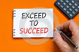 Exceed to succeed symbol. Concept words Exceed to succeed on beautiful white note. Beautiful orange background. Businessman hand.