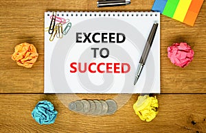 Exceed to succeed symbol. Concept words Exceed to succeed on beautiful white note. Beautiful wooden background. Black pen. Colored