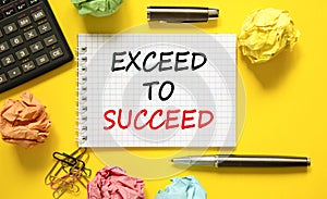 Exceed to succeed symbol. Concept words Exceed to succeed on beautiful white note. Beautiful yellow background. Black pen. Colored