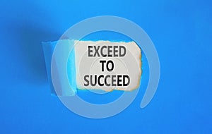 Exceed to succeed symbol. Concept words Exceed to succeed on beautiful white paper. Beautiful blue paper background. Business and