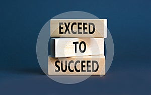 Exceed to succeed symbol. Concept words Exceed to succeed on beautiful wooden blocks. Beautiful grey table grey background.