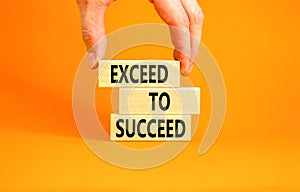 Exceed to succeed symbol. Concept words Exceed to succeed on beautiful wooden blocks. Beautiful orange table orange background.