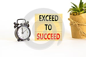 Exceed to succeed symbol. Concept words Exceed to succeed on beautiful wooden blocks. Beautiful white table white background.